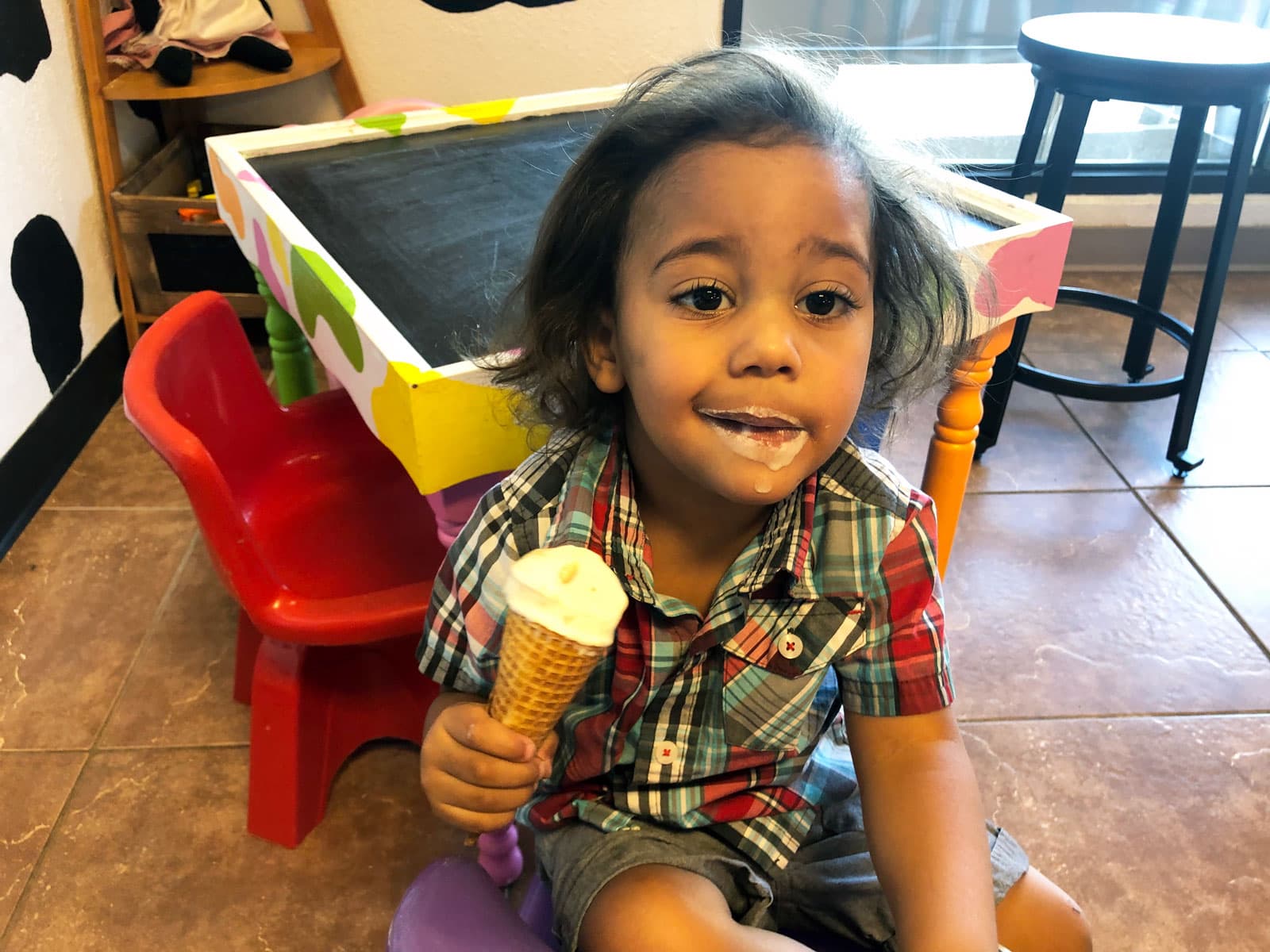 A child dug into their vanilla ice-cream cone with relish and now has a ring of food around their mouth at the Caffeinated Cow in Colorado.