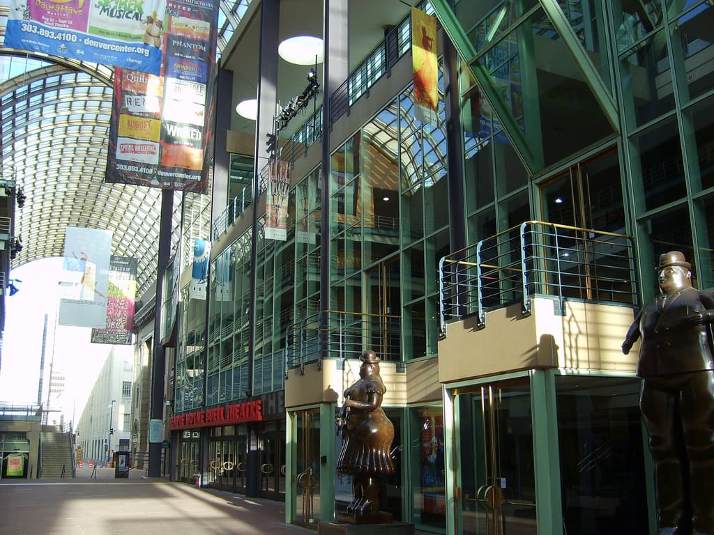 Exterior view of a glass-walled performing arts center in a downtown area
