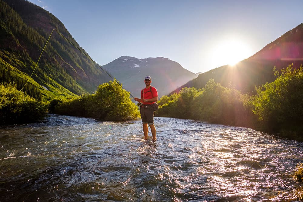 A person fishing on a sparkling river north of Durango, outside of Silverton