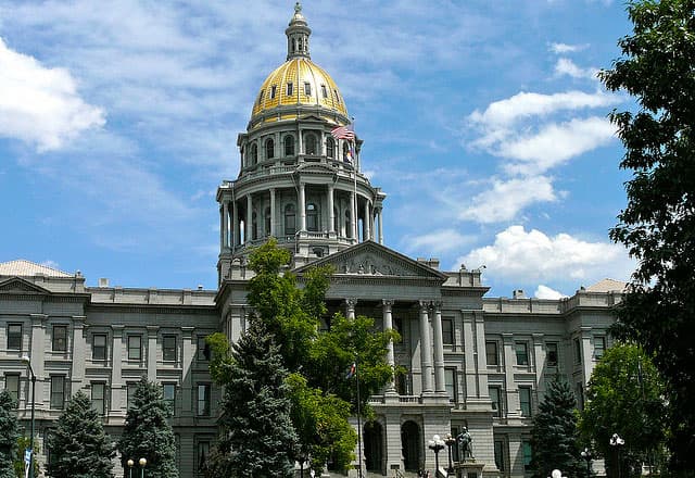 In Denver, Colorado, a shiny, golden dome caps the capitol building. The dome sits atop two tiers of tall windows and imposing columns.