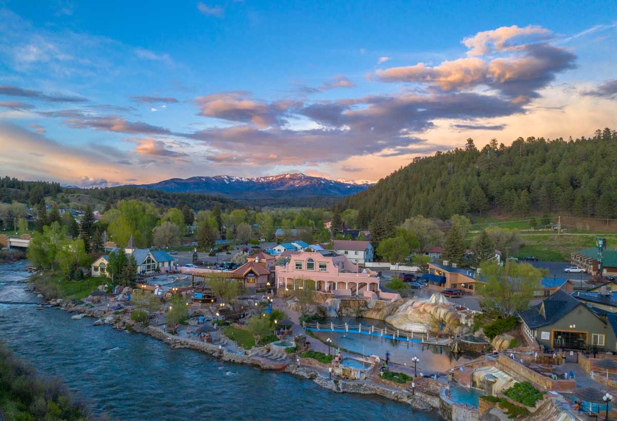 The summer sky begins to darken and lanterns begin to light up as night sets in at The Springs Resort & Spa in Pagosa Springs, Colorado.