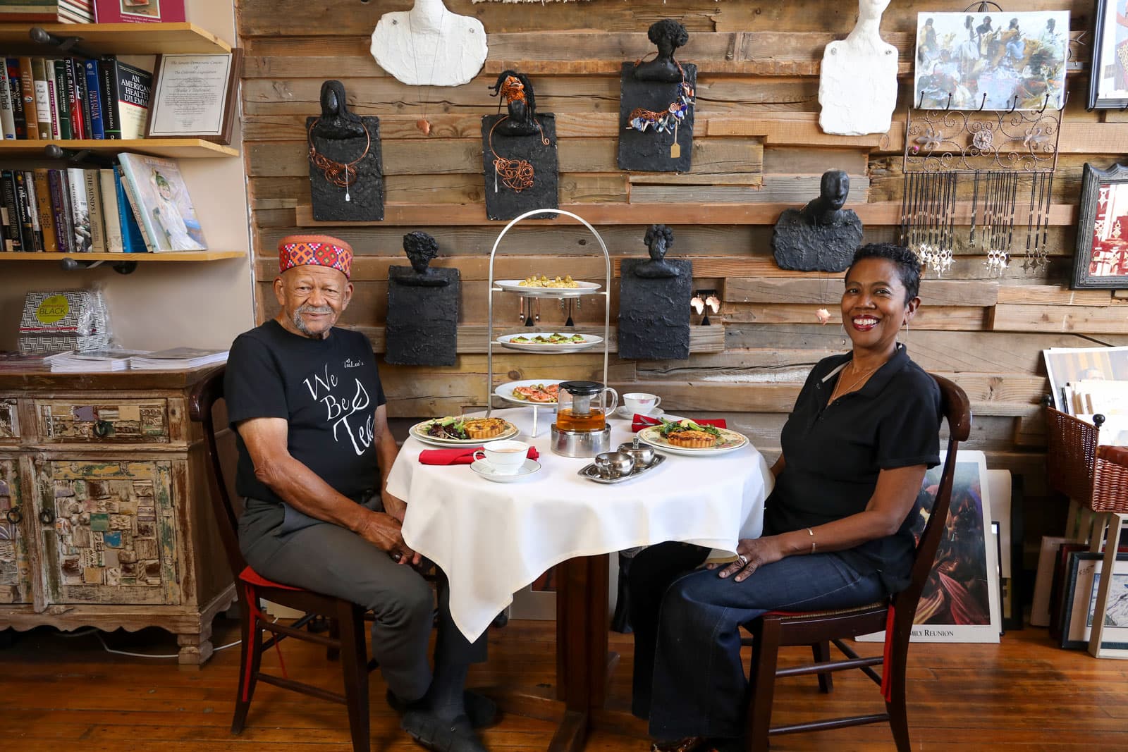 A couple sits down to enjoy trays of food and cups of hot tea at an afternoon tea at TeaLee's Tea Co. in Colorado.
