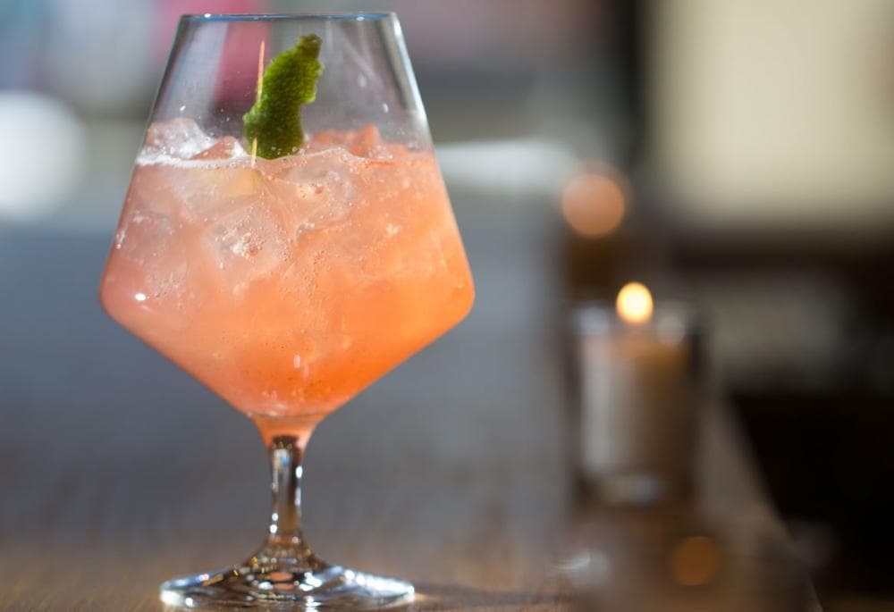 An icey peach cocktail in a clear, stemmed glass at Root & Flower in Vail