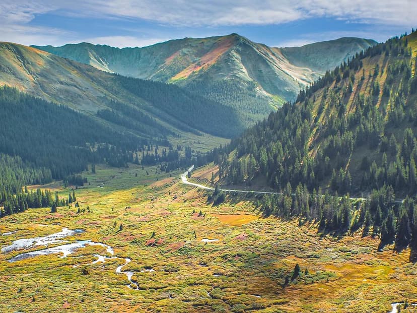 A meandering road cuts through sunlight-dappled mountain scenery near Leadville and Twin Lakes. A meandering road cuts through sunlight-dappled mountain scenery near Leadville and Twin Lakes.