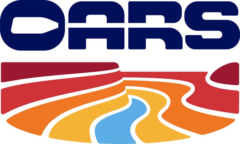 OARS rafting logo. OARS in dark blue letters above a series of wavy lines in red orange yellow and blue depicting a river running through a canyon.