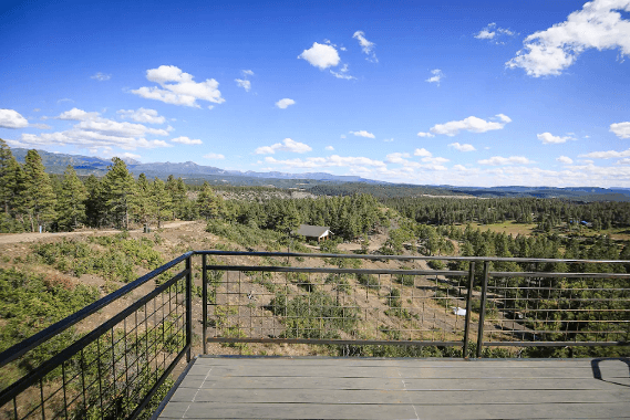See expansive tree-lined views from the deck of The Ridge cabin in Pagosa Springs.