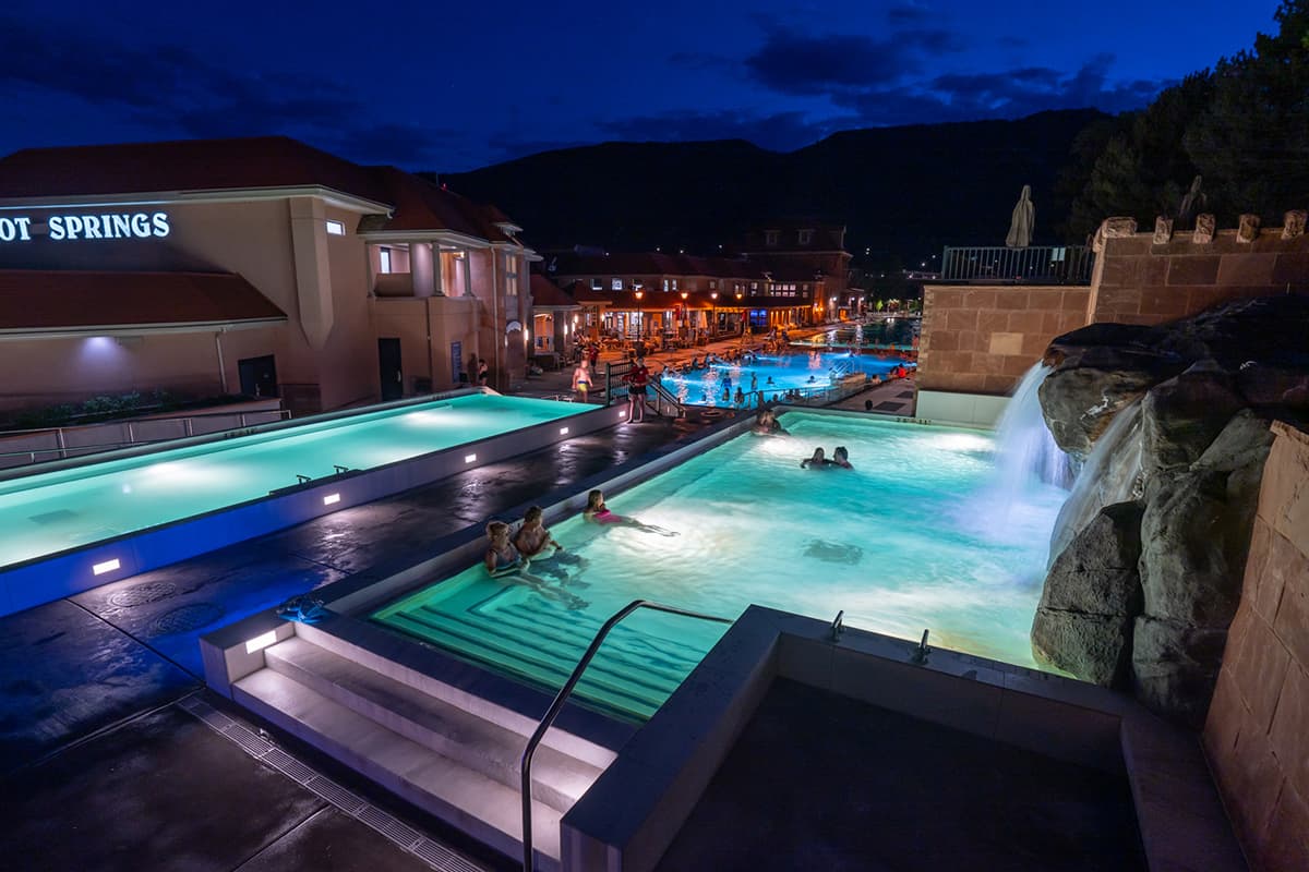 At Glenwood Hot Springs Resort, the pools glow with soft lighting amid the darkness of the evening.