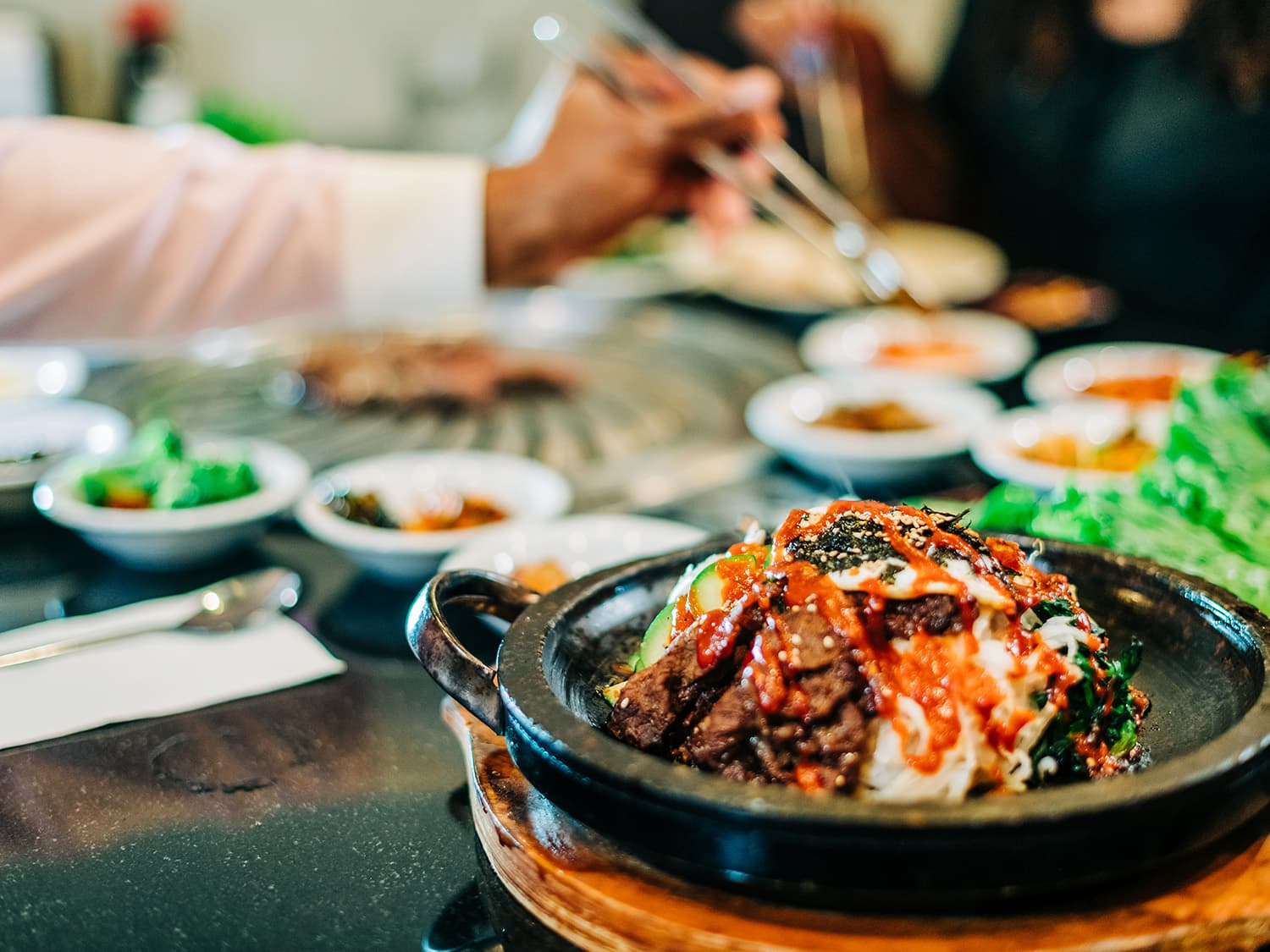Banchan appetizers and marinated and cooked beef topped with egg, seaweed and vegetables at a Korean restaurant in Aurora Colorado.