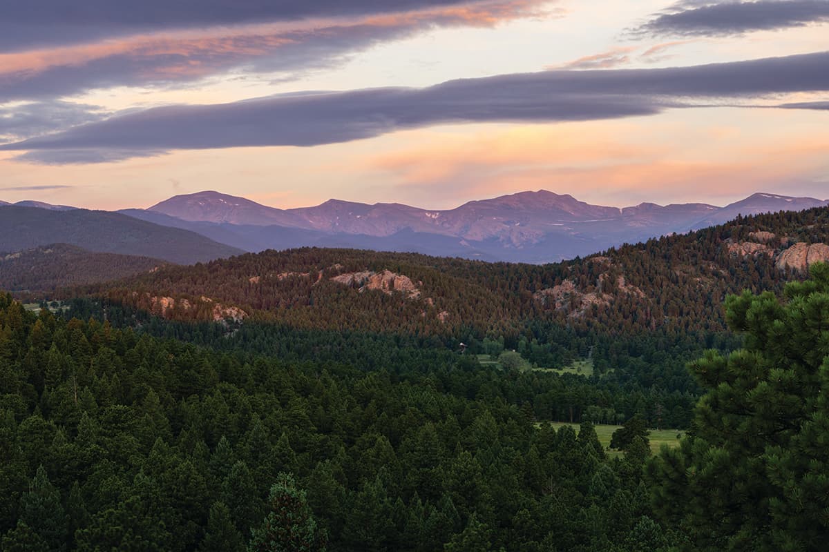 Golden hour casting over mountains and trees above Alderfer/Three Sisters.