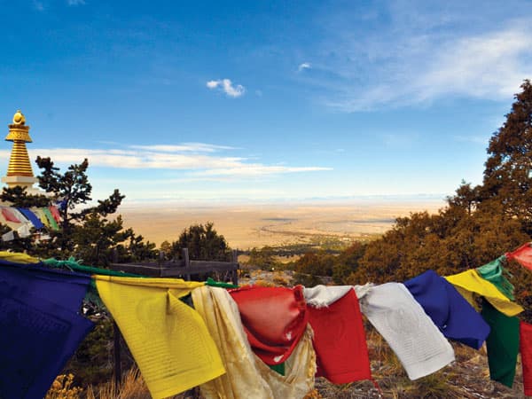 Colorful fabrics hang on a line with a mountain valley in the background