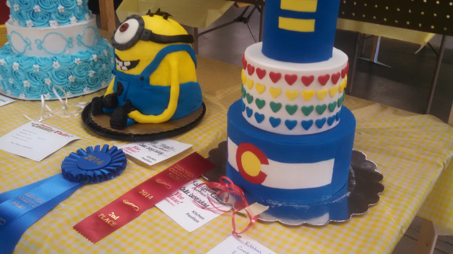 Colorful ribbons and prizes awarded to layered cakes at the Denver County Fair