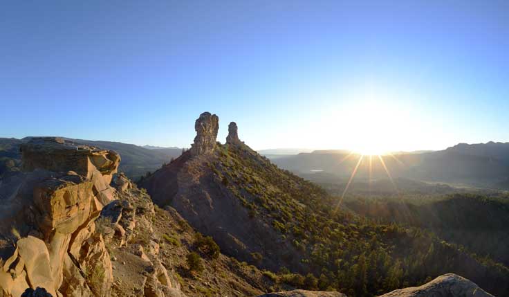 The sun sets over a mountain during the Summer Solstice Program at Chimney Rock
