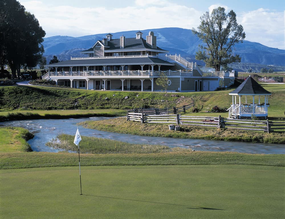 A small white flag marks the golf hole and a well-maintained, green golf course in Gypsum, Colorado.