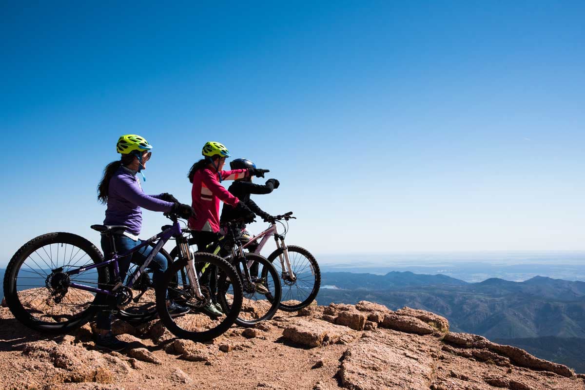 A family pauses at a view point on a Colorado mountain trail