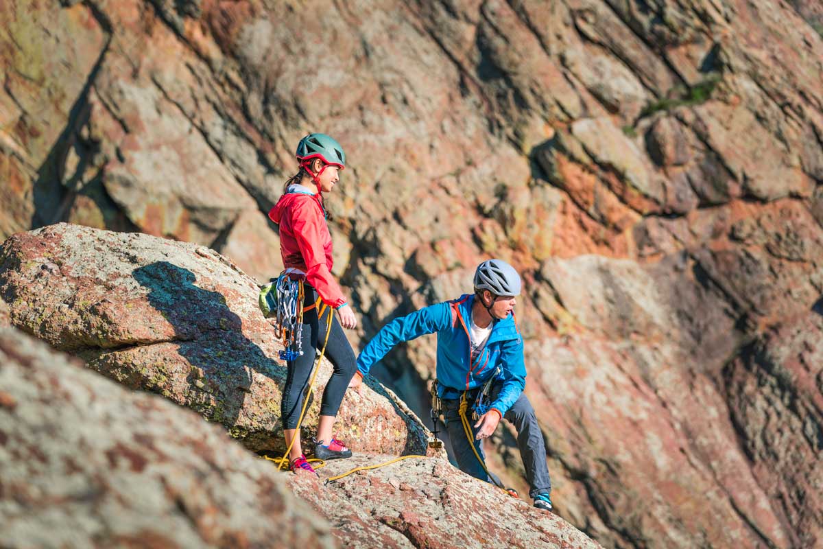 Two adventurers make it to the top of a red rock wall in Colorado. They catch their breath and admire the off-camera view.