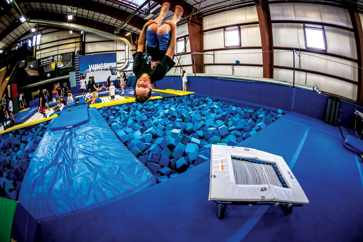 A child flipping in the air over a foam pit