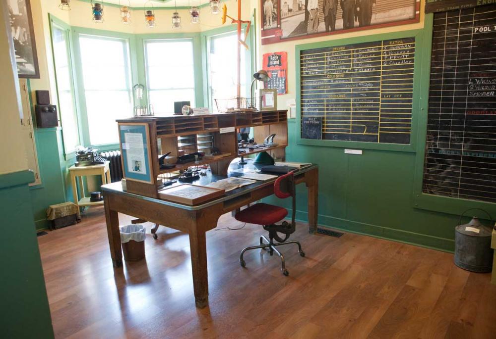 An old railroad office is staged with large, wooden desk, featuring lots of paper slots and cubbies, and two massive chalkboards in Colorado.