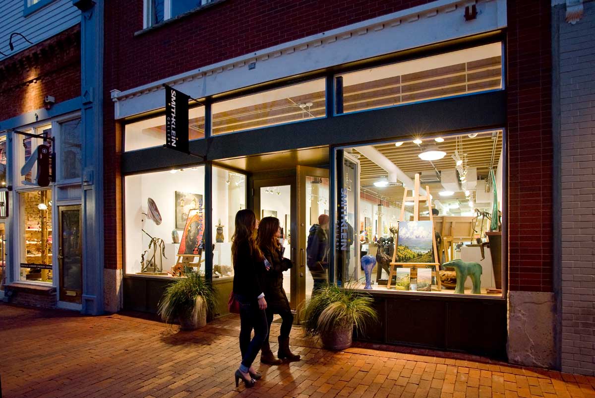 Two woman enjoy Boulder’s arts and culture scene at a gallery at night