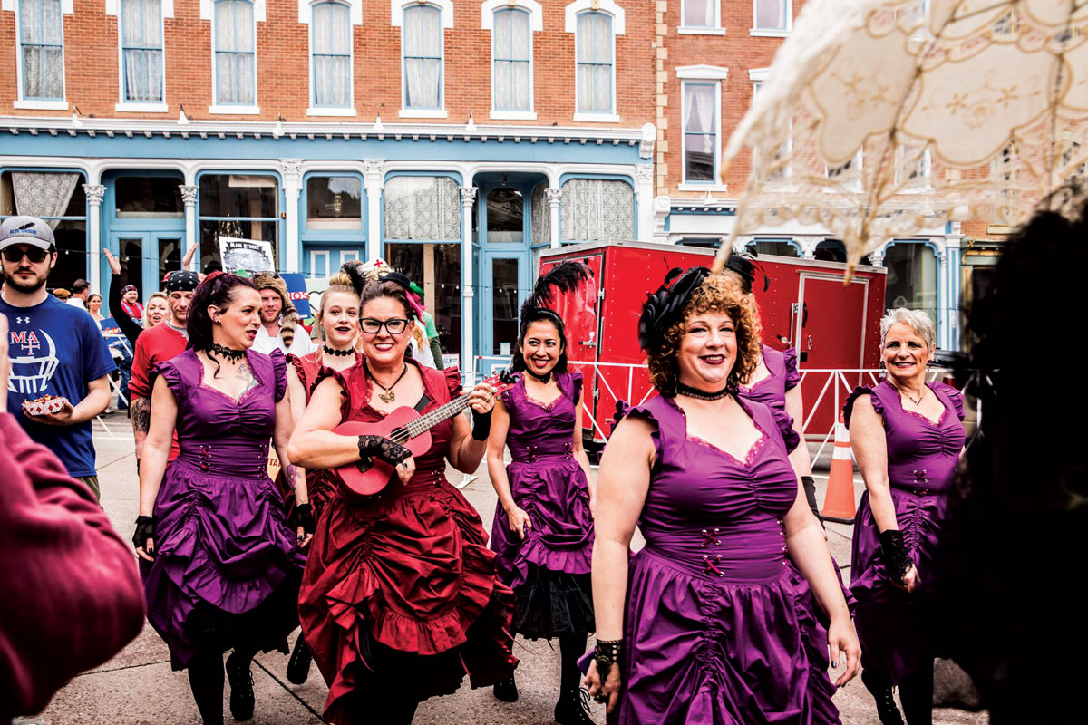 Revelers in red and purple costumes enjoy Madam Lou Bunch Day in Central City