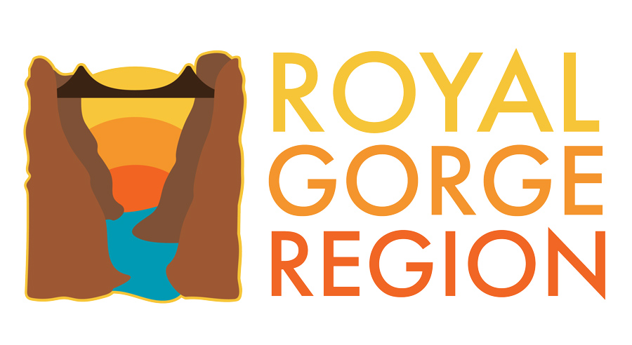 Royal Gorge Region Logo Royal Gorge Region Logo — an illustration of a blue river running through a brown canyon with a bridge stretching over it and a sunrise in the background