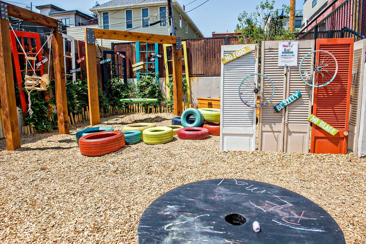Blue, yellow, red and orange tires, rope swings and other colorful play accessories are set up on a wood-chip lot at the Acova Restaurant in Colorado.