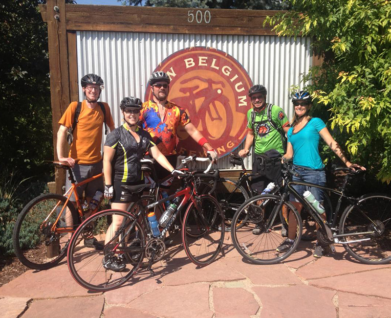 Beers and bike tours in Fort Collins Five people in biking attire pose for a photo at New Belgium Brewing in Fort Collins. They wear helmets and hold their bikes.