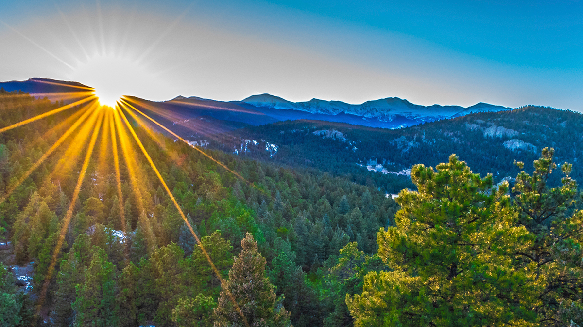 A sunrise rising over mountains in Evergreen.