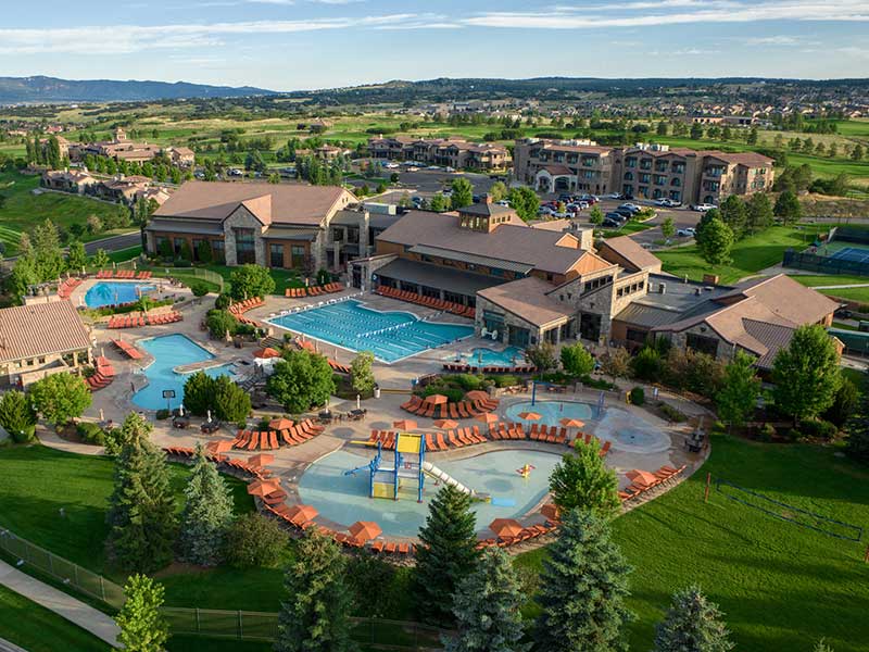 The buildings of a resort hotel, surrounded by several swimming pools and golf courses