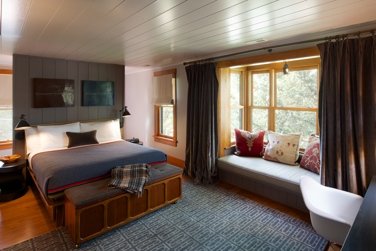 This spacious guest room at the Outlook Lodge features a window sitting space and desk area. Large windows bring in lots of natural light.