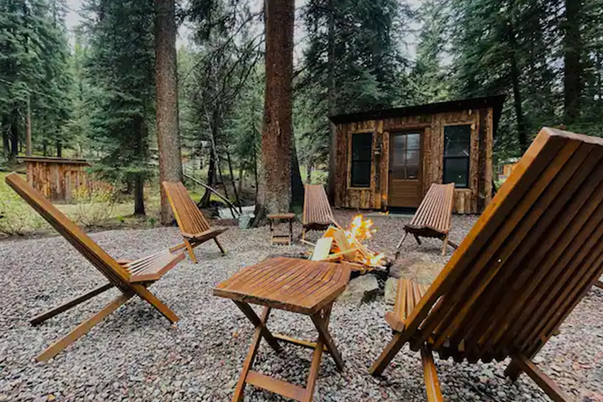 Wooden chairs make a ring around a blazing firepit near Conifer, Colorado.
