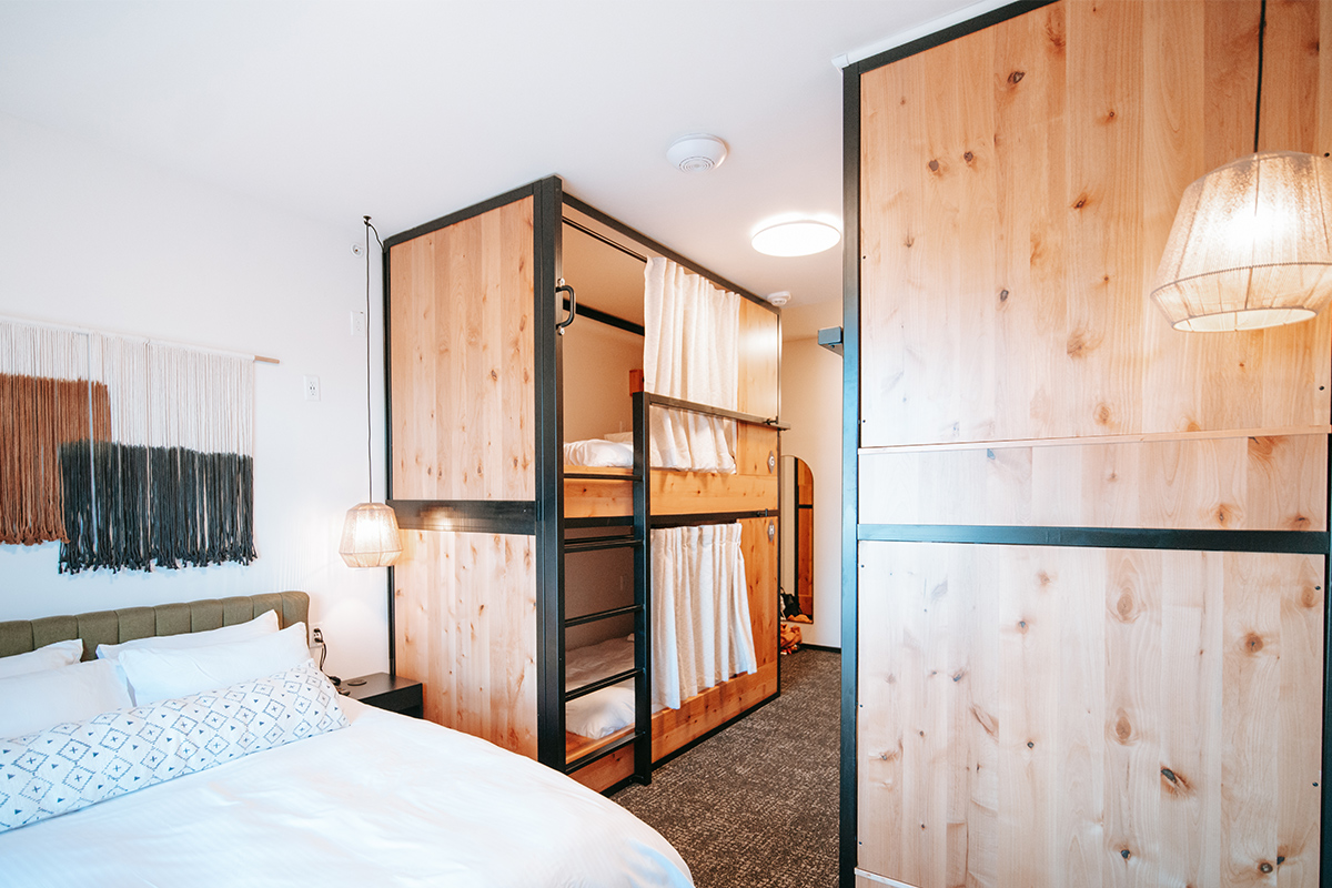 The family suite at Kinship Landing features a large bed for parents and several pod-style bunk beds for kids.