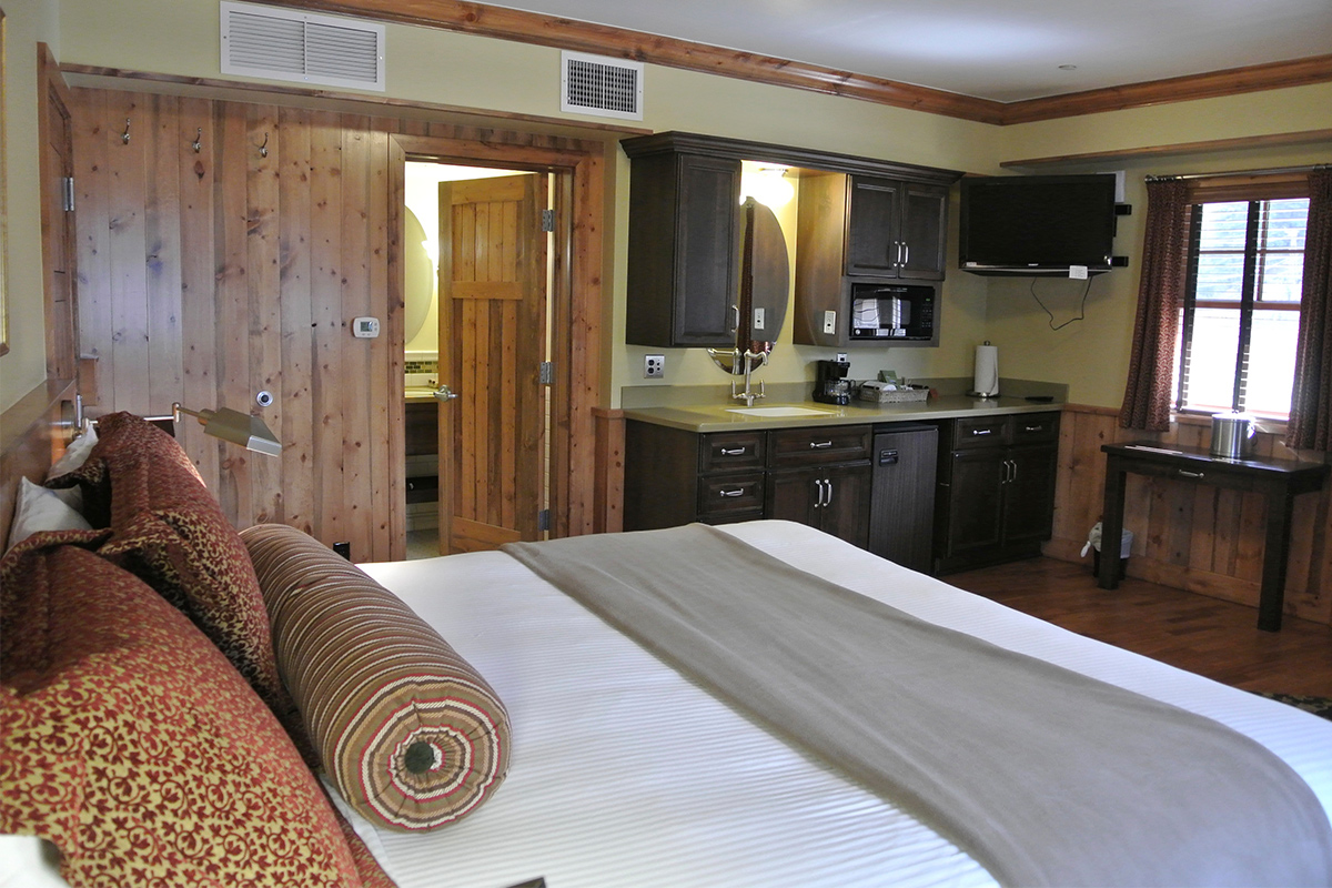 The king suite at the Green Bridge Inn charming and rustic. It has knotty, wood floors, doors and molding.