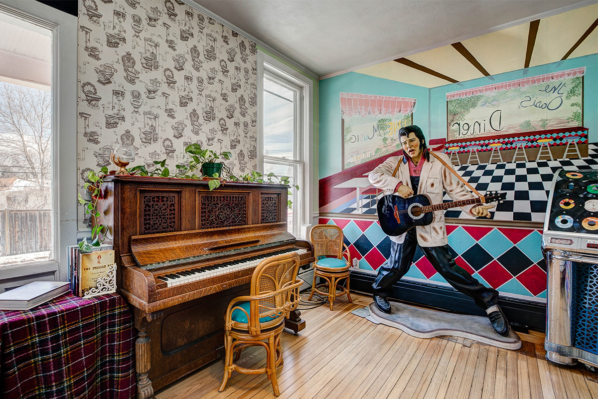 A retro diner mural sets the scene for a vinyl-cover jukebox and a rockin' Elvis statue in one of the rooms at The Oasis on Eisenhower.