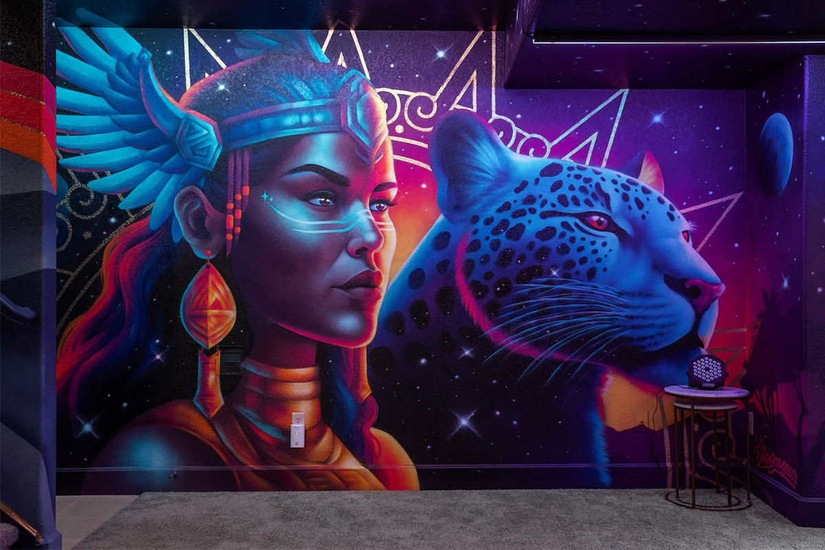 A mural of a warrior and her leopard companion fill a wall with brilliant, deep colors at at Hummingbird Hill in Colorado.