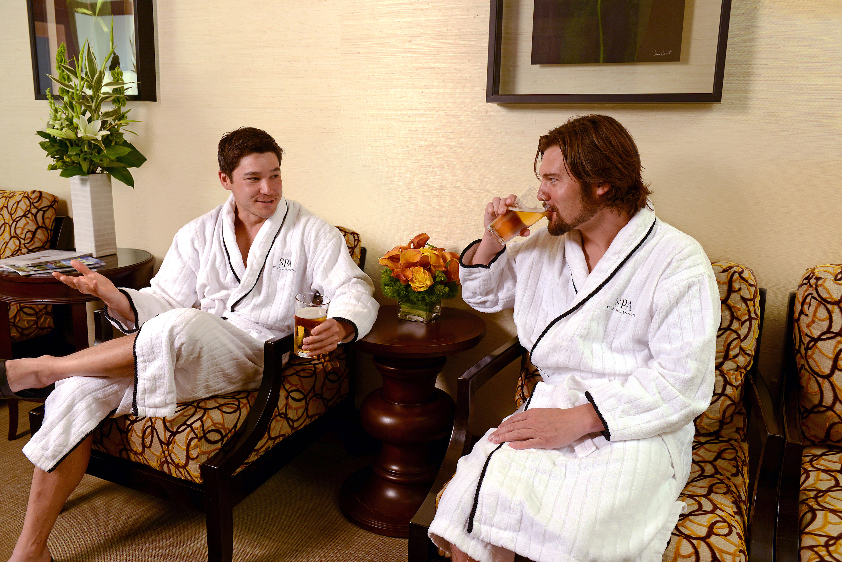 Two men sip beverages while wearing robes at the spa in Boulder's St. Julien Hotel & Spa.