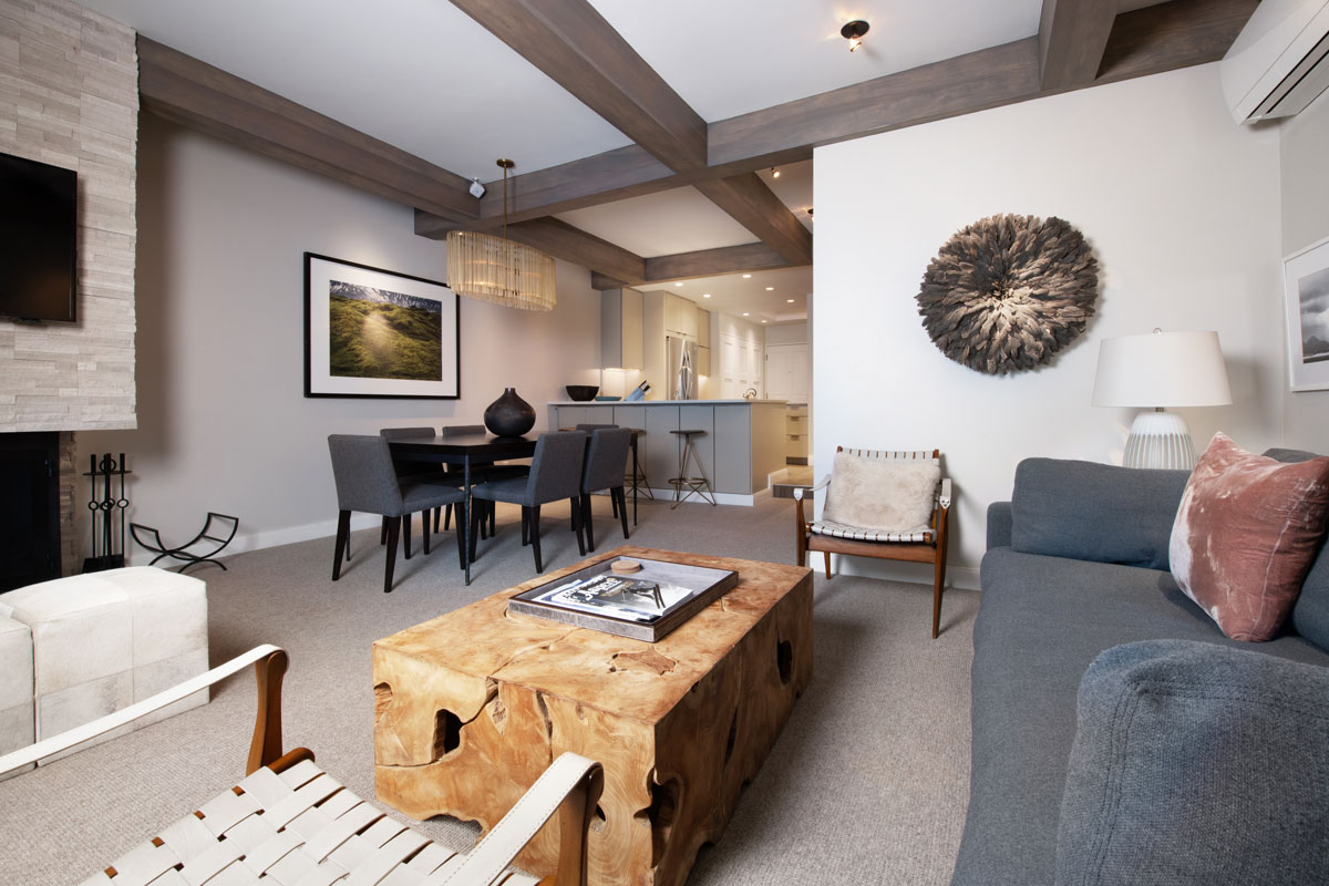 A condo-style living room at The Gant, featuring plush furnishings and dark-wood ceiling beams