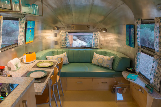 Inset green-couch lounge area within Canyon Hideout Bungalow Airstream