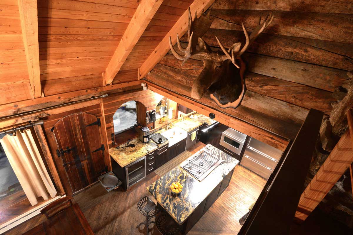 Interior cabin view of The Observatory at Alta Lakes with a moose head on the wall and the kitchen below