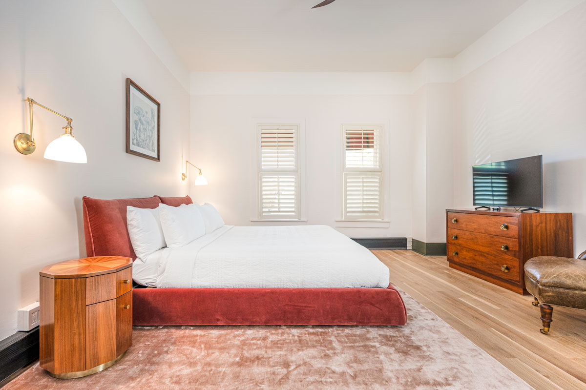 Hotel Room at The Rochester Hotel in Durango with plush red bed stand, white walls and cozy furnishings