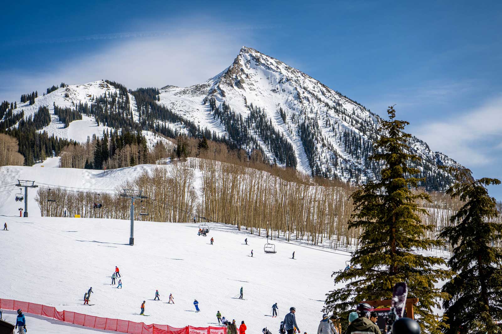 A snowcovered peak in Crested Butte lined with ski runs under a blue sky