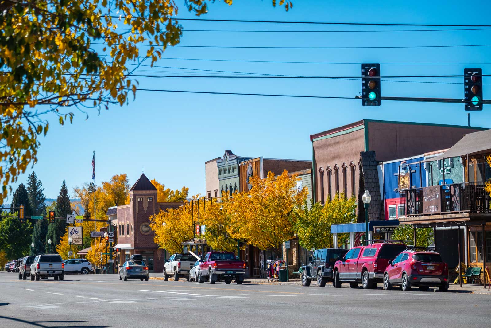 Historical brick buildings line Gunnison's main street; the trees' leaves are changing color