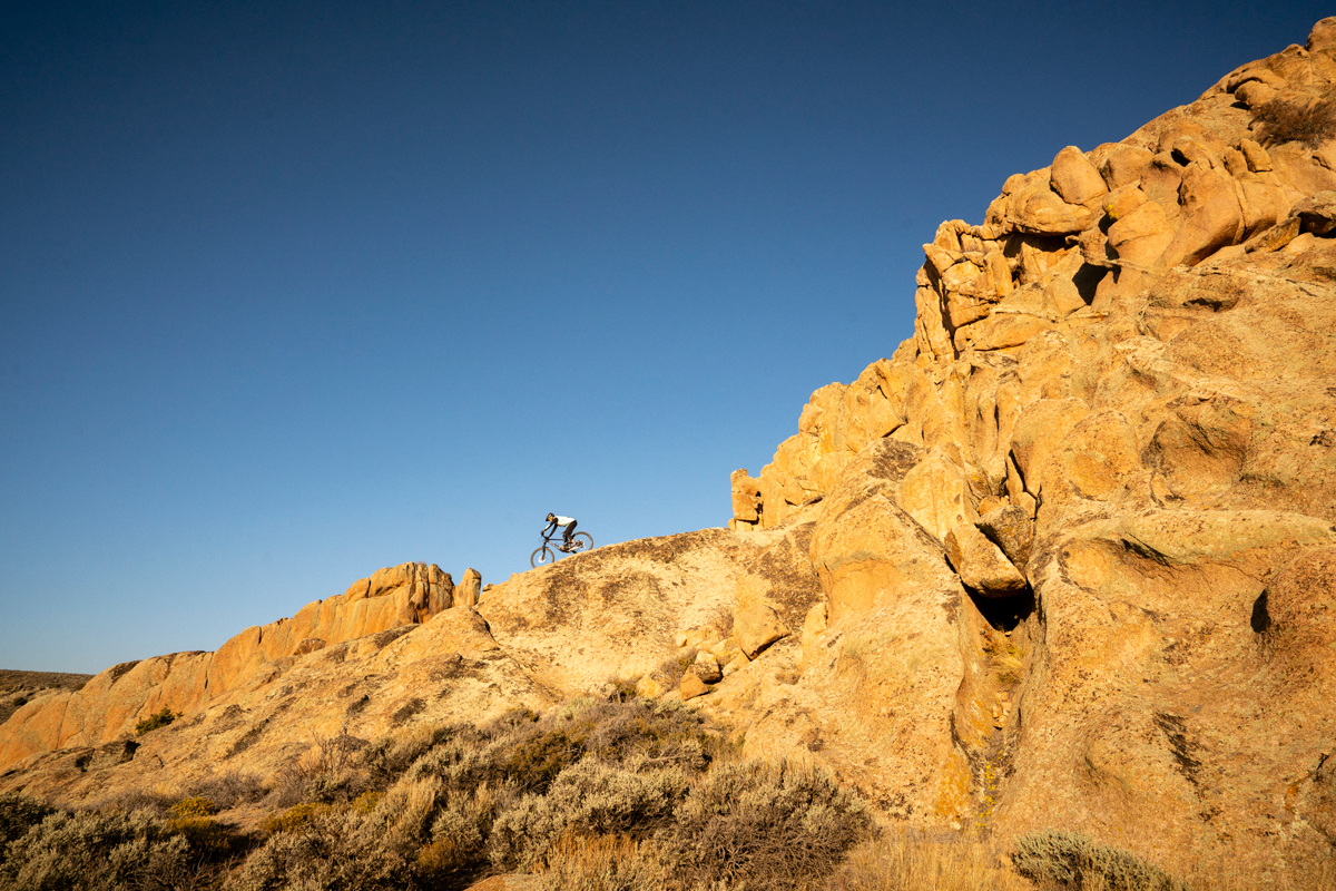 A mountain biker rides along the top of a craggy rock face at Hartman Rocks Recreation Area in Crested Butte, Colorado.