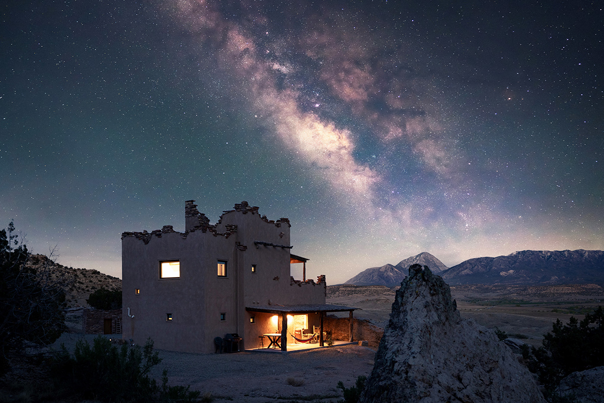 Above one of the buildings of the Canyon of the Ancients Guest Ranch the inky sky glows with stars and the cosmic swirls of the Milky Way.