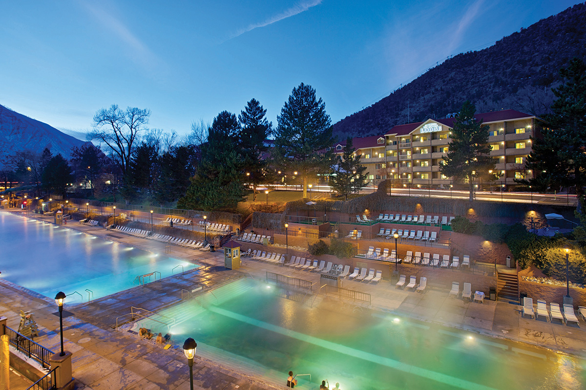 The sky darkens around Glenwood Hot Springs Resort and soft lights turn on around the pools.