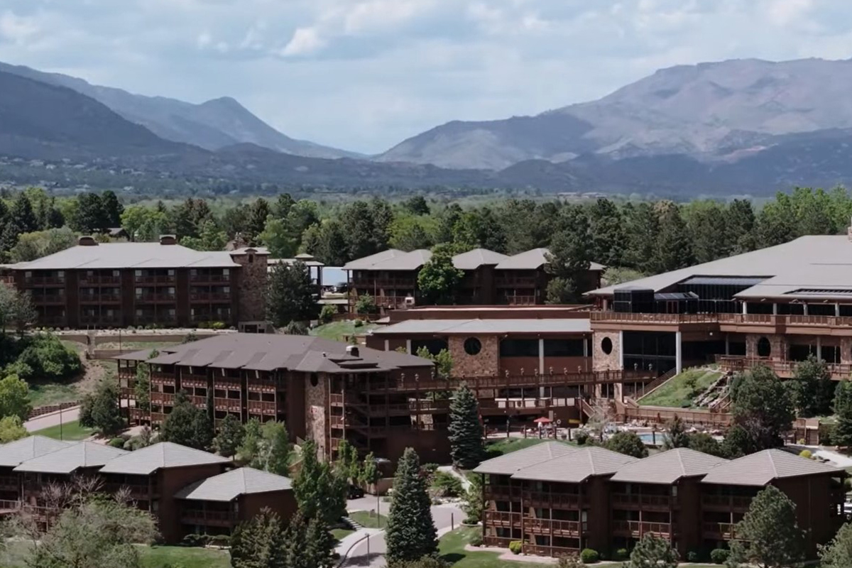 Behind the multi-story buildings of the Cheyenne Mountain Resort near Colorado Springs, Colorado, towering peaks rise up to meet the sky.