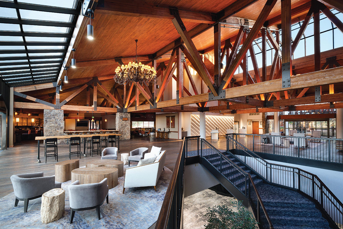 At Cheyenne Mountain Resort, a large community space features vaulted wood-paneled ceilings with expose beams and chic areas for sitting and relaxing.