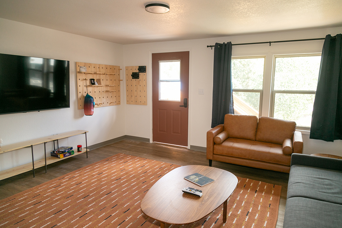 A guest room at LOGE Wolf Creek shows a bright space with plenty of opportunities to relax and store sports gear.