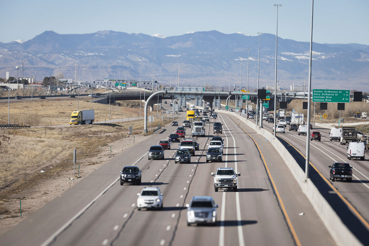 Aerial view of vehicles on the road and white car crossing a solid line, violating a Colorado Express Lane rule.