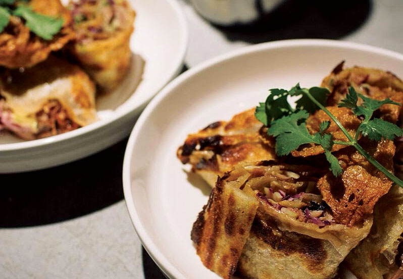 Two white bowls hold an Asian-inspired meal