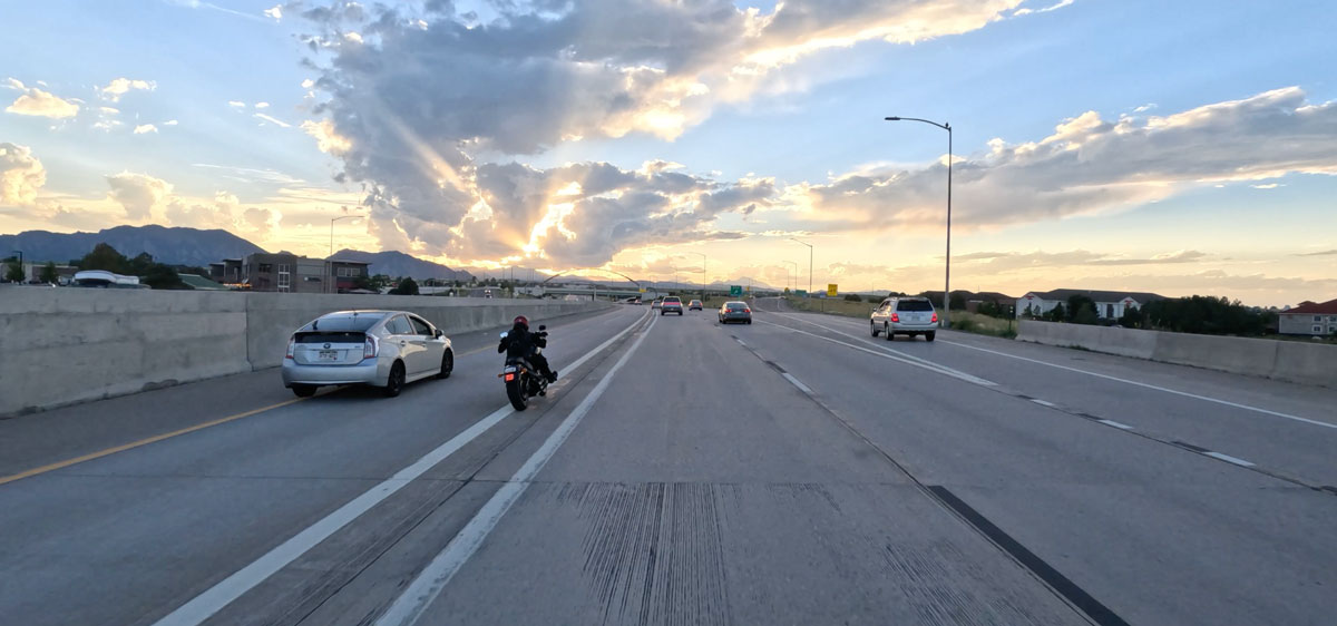A motorcycle rider improperly entering the Colorado Express Lane by crossing a solid white line.